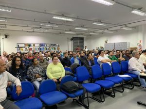 plateia no auditório e palestrante à frente