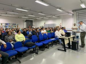 plateia no auditório e palestrante à frente